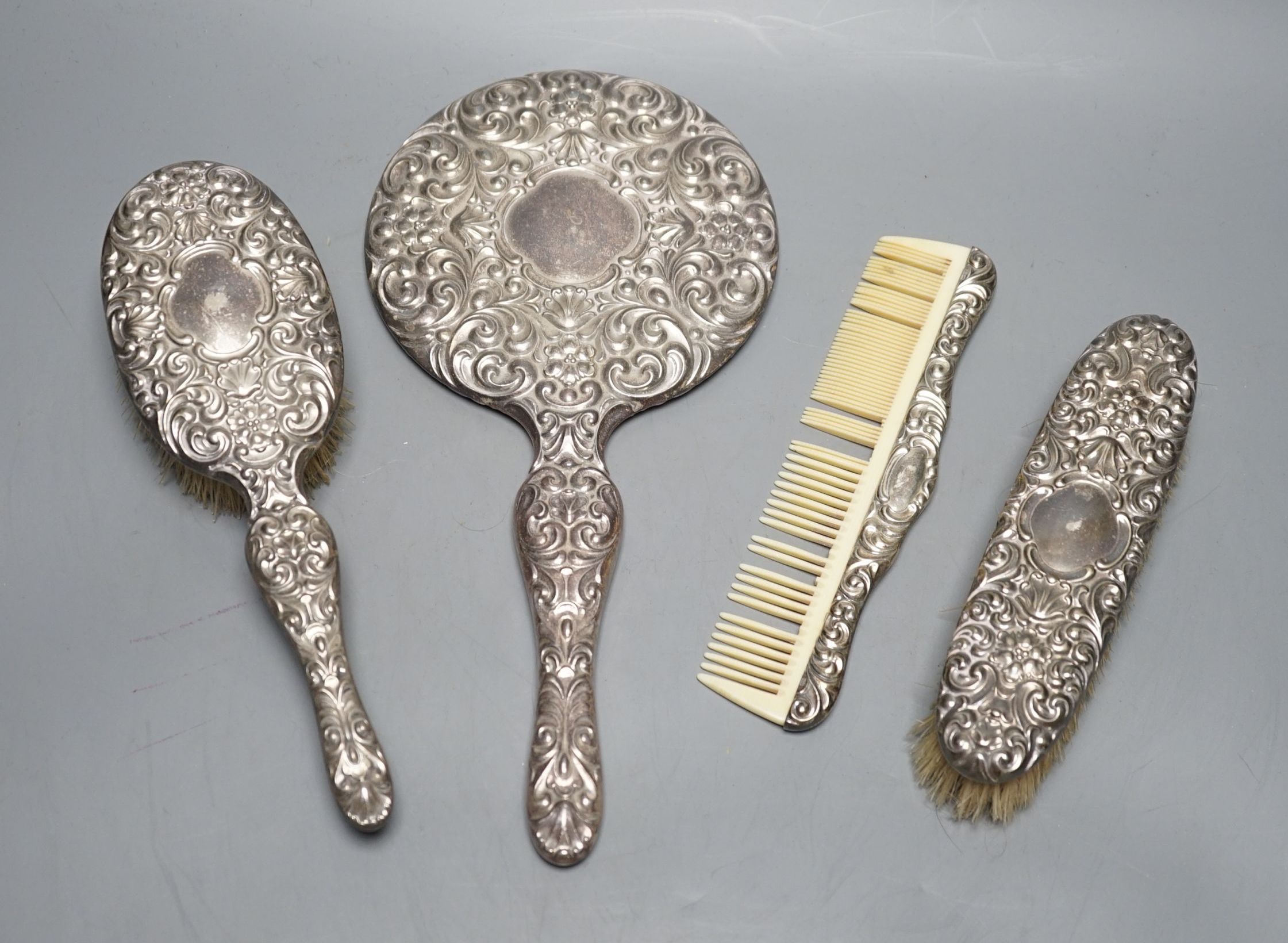 A continental 800 standard white metal mounted four piece mirror and brush set.